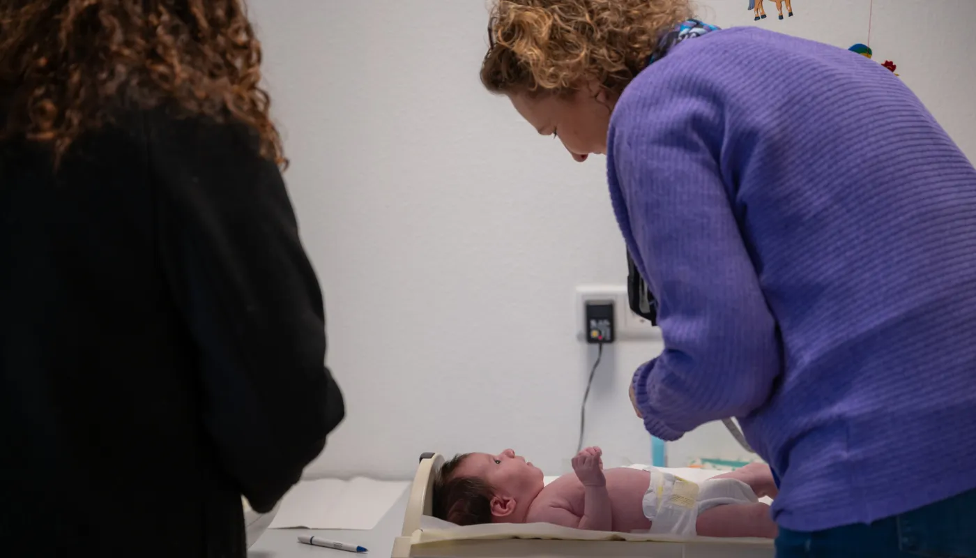 GGD verpleegkundige die een baby op het consultatiebureau controleert.