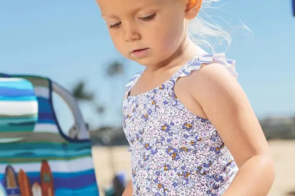 Meisje op het strand met een schep en emmer.