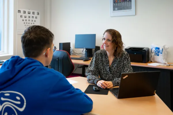 Jeugdverpleegkundige van GGD Zeeland op middelbare school. De jeugdverpleegkundige neemt een gesprek af met een scholier.