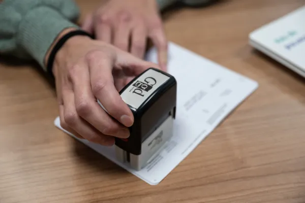 Een hand die een stempel van een vaccinatie zet in het vaccinatieboekje